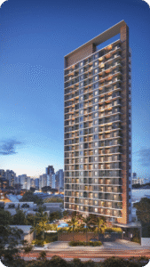 Vista noturna da fachada principal de uma torre de apartamentos de alto padrão em Fortaleza (LIKE Residencial). O prédio alto possui design moderno com acabamento amadeirado no topo e lateral, e o térreo exibe uma área de lazer iluminada com piscina e coqueiros, em um cenário urbano.