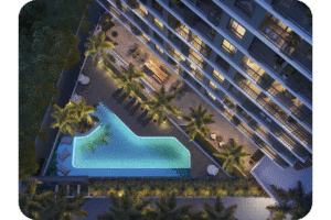 Vista aérea da área de lazer do empreendimento de luxo LIKE Residencial. A imagem noturna destaca uma piscina de formato orgânico com iluminação azul, deck de madeira, espreguiçadeiras, área gourmet ou de convívio com mesa e paisagismo com palmeiras, ao lado da fachada do edifício.