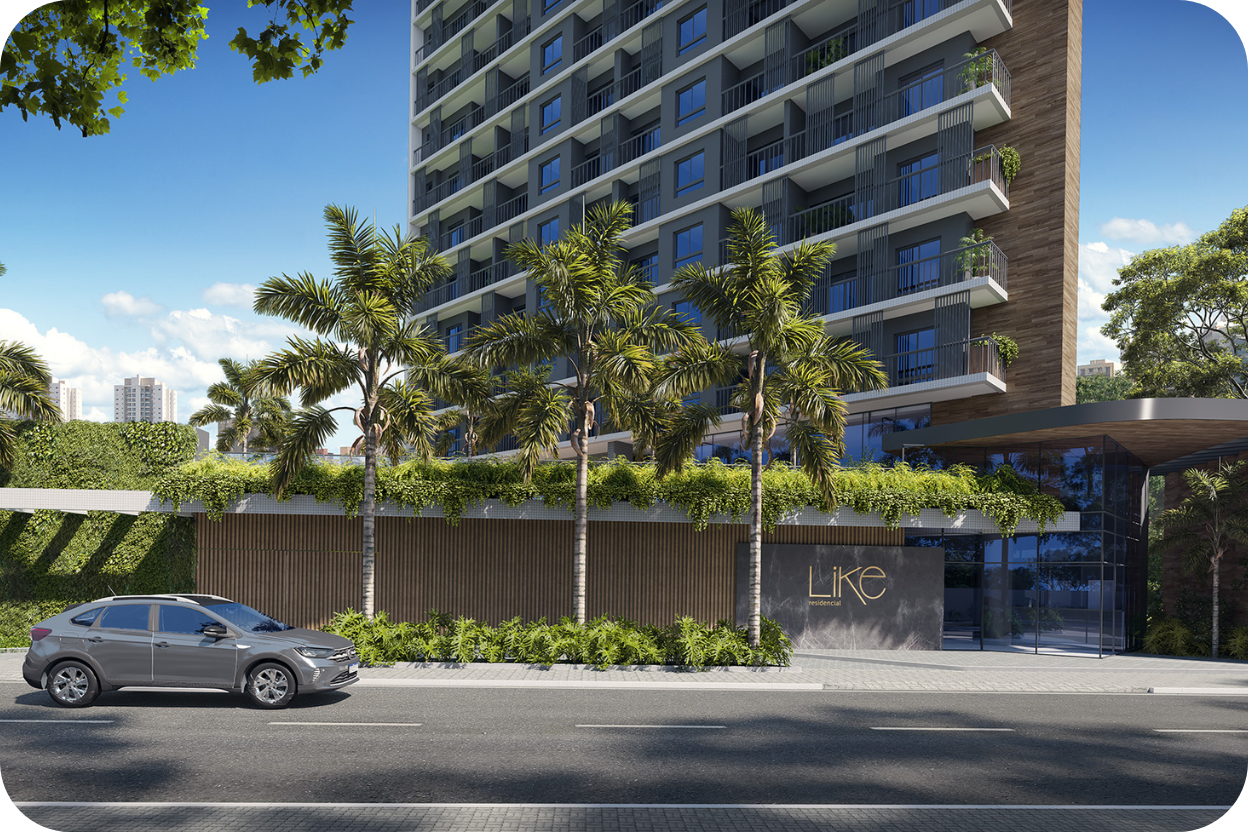 Vista do térreo da torre residencial de alto padrão LIKE Residencial. A imagem destaca a entrada envidraçada com a logo do empreendimento, um painel de madeira na base, abundante vegetação lateral e coqueiros, além de um carro cinza estacionado na rua.